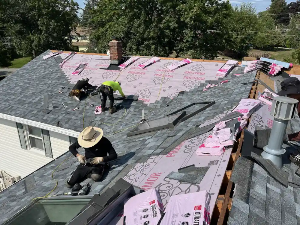 Roofer installing asphalt shingles on suburban home in Hackensack, New Jersey